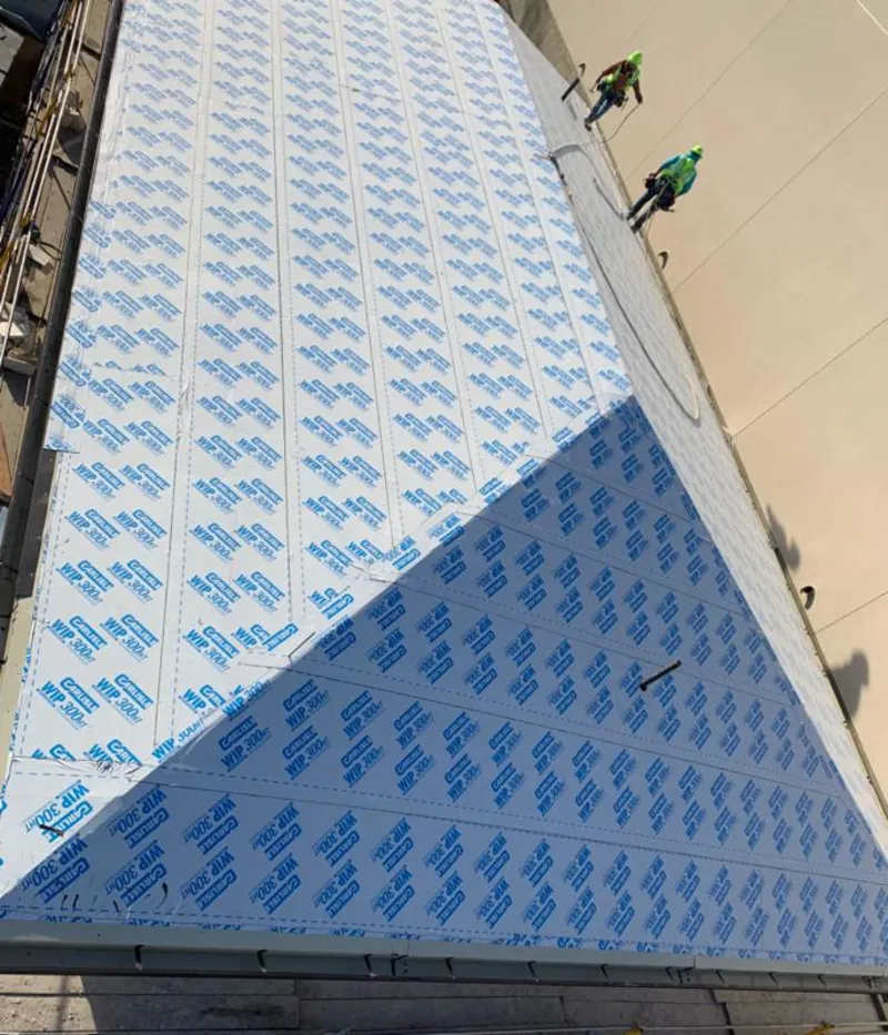 Professional roofers installing underlayment on a metal roof in Columbus